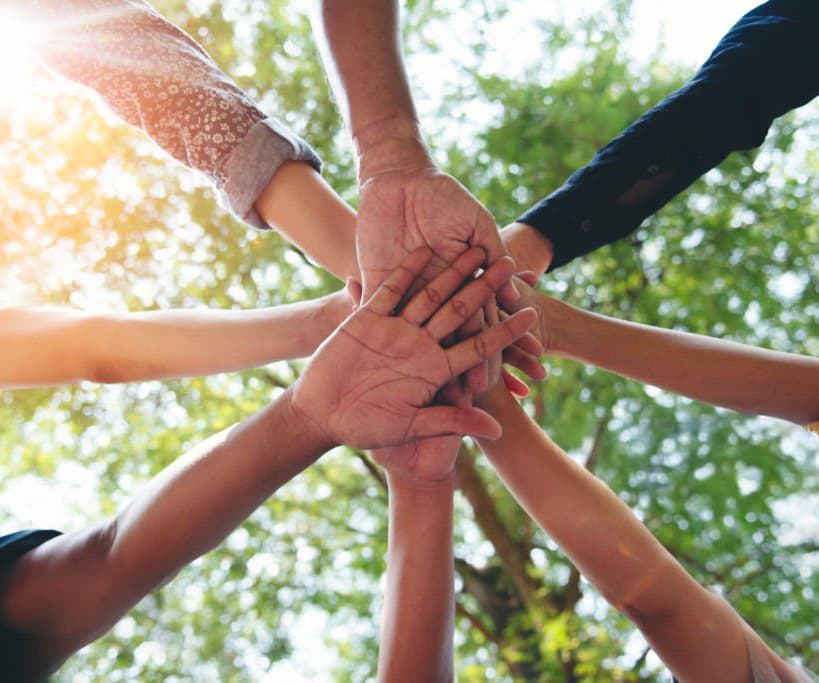 Hands stacked together in teamwork.